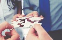 Group of business people holding a jigsaw puzzle pieces. Business solution integration concept. Multi ethnic group. Close up of hands