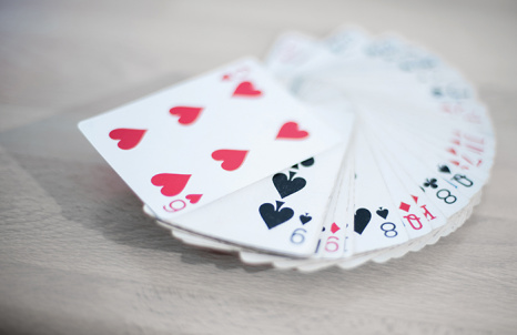 Playing cards deck isolated on a gray wooden background - red, black, and white colors